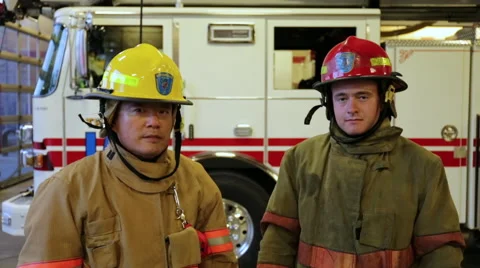 Two firemen putting on helmets and looking into the camera, portrait Stock Footage 66548859