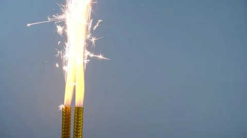 Two firework sparklers burning on blue background. Stock Footage 279884605