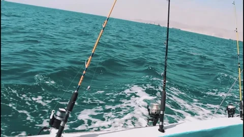 Two fishing rods trolling on a fast boat with sea wake Stock Footage 320090965
