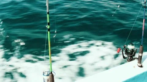 Two fishing rods trolling in the wake of a fast moving boat on the sea Stock Footage 312042017