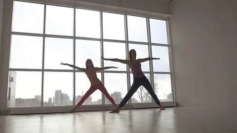 Two fit female friends doing in yoga class with natural light Stock-Footage 72564458