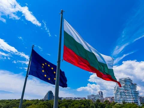 Two flags are flying high in the air. The Bulgarian flag is red, green, and w 写真素材