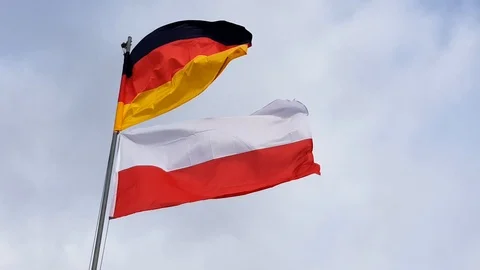 Two flags German and Polish moving in the wind the blue cloudy sky in the back Stock Footage 104606687