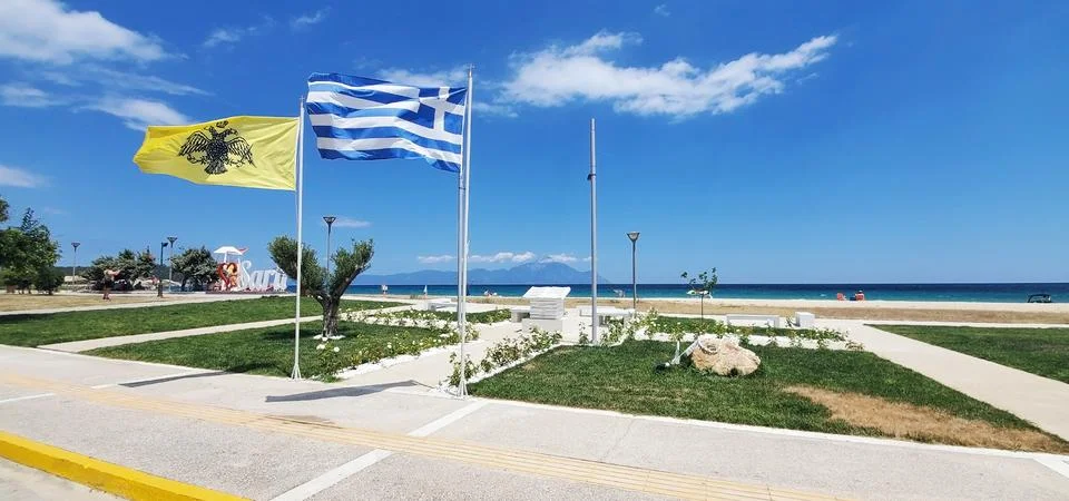 Two flags on a seafront promenade in Greece Stock Photos