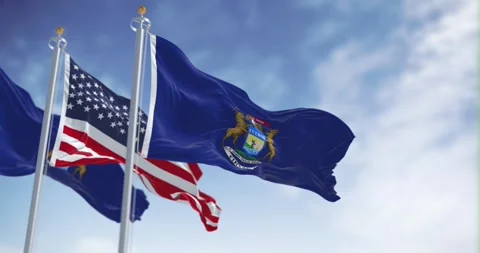 Two flags of the state of Michigan waving in the wind with the american flag Video stock 253561339