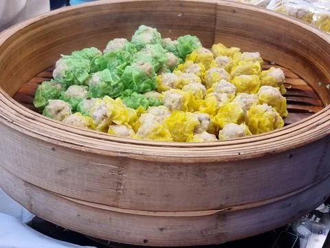 Two flavors of dumplings in two colors, green and yellow, are being steamed.. Stock Photos