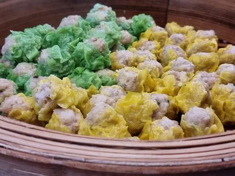 Two flavors of dumplings in two colors, green and yellow, are being steamed.. Stock Photos