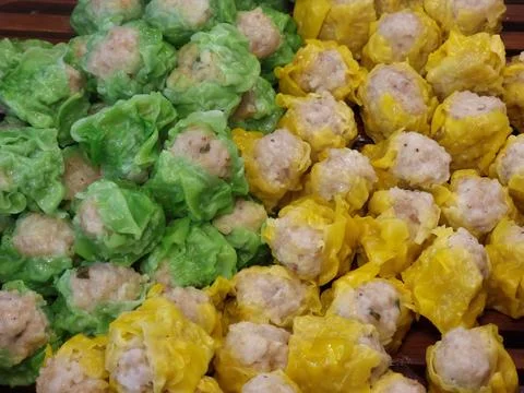 Two flavors of dumplings in two colors, green and yellow, are being steamed.. Stock-Fotos