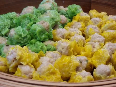 Two flavors of dumplings in two colors, green and yellow, are being steamed.. Stock Photos