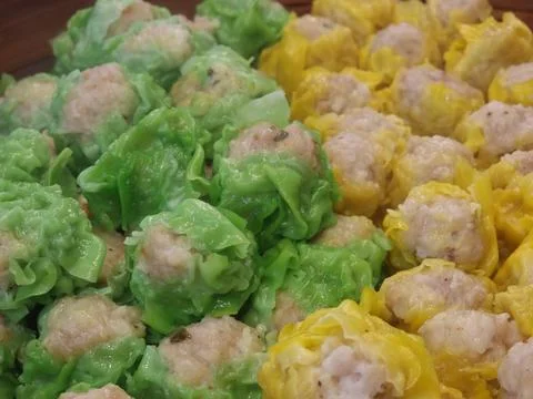 Two flavors of dumplings in two colors, green and yellow, are being steamed.. Stock Photos
