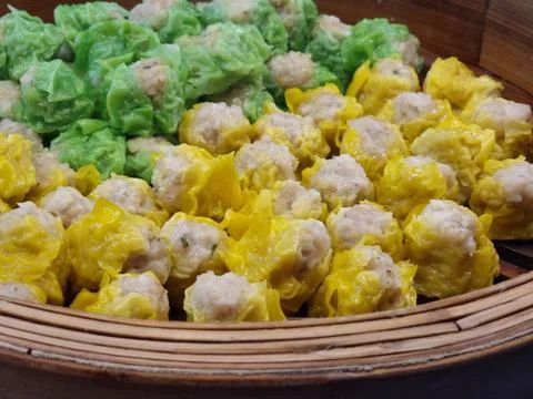 Two flavors of dumplings in two colors, green and yellow, are being steamed.. Stock Photos