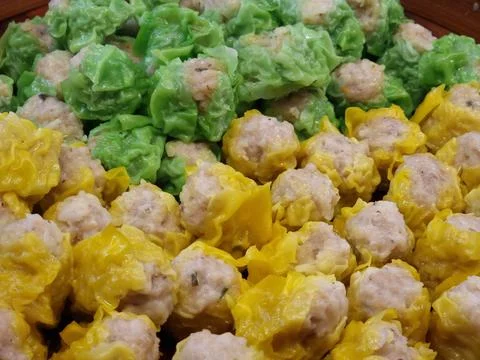 Two flavors of dumplings in two colors, green and yellow, are being steamed.. Stock Photos