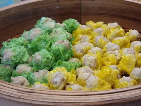 Two flavors of dumplings in two colors, green and yellow, are being steamed.. Stock Photos