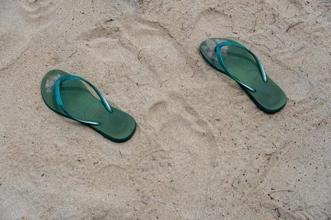 Two flip flops are laying on the sand Foto stock