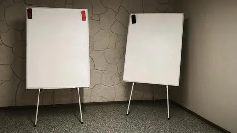 Two flipchart boards placed side by side in classroom with stone wall background Stock Photos
