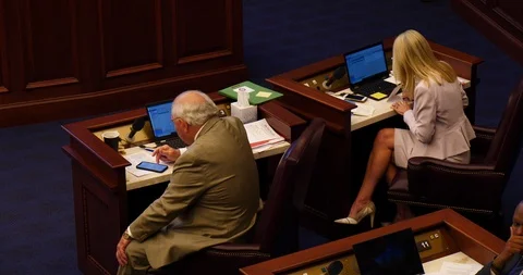 Two Florida state senators work at desk during senate floor debate 2019 session Stock Footage 107506587