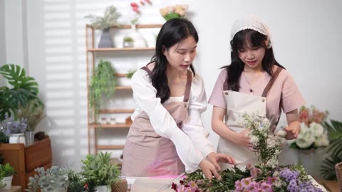 Two florists carefully selecting flowers to create a beautiful bouquet, foc.. Stock Footage 296755311