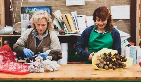 Two florists work in a nursery. Stock Photos