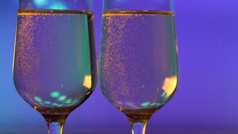 Two flutes of champagne with bubbles on blue background. Stock Footage 111079298