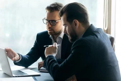 Two focused businessmen developing marketing company in office. Stock Photos