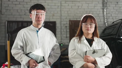Two Focused Students Standing Near Engine in Mechanical Workshop Holding Tablets Stock Footage 301247873