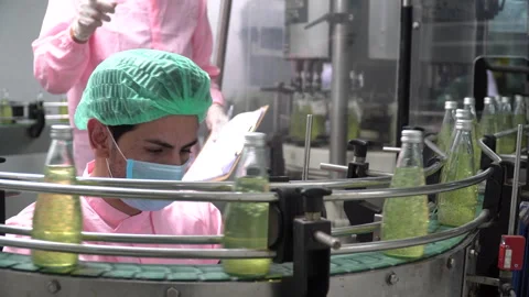 Two food scientist worker wearing hairnet and face mask discussing while chec Stock Footage 142700634