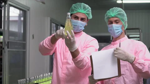Two food scientist worker wearing hairnet and face mask discussing while chec Stock Footage 159659172