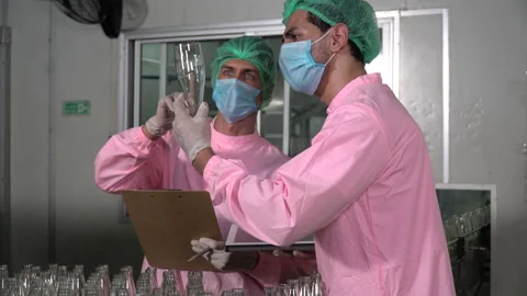 Two food scientist worker wearing hairnet and face mask discussing while chec Stock Footage 159661680