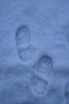 Two Footprints Pressed Deep into Blue-Toned Snow Stock-Fotos