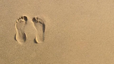 Two Footprints in the sand on the beach Stock Photos