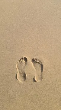 Two Footprints in the sand on the beach Stock Photos