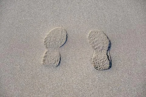 Two footprints in the sand, one on the left and one on the right 스톡 사진
