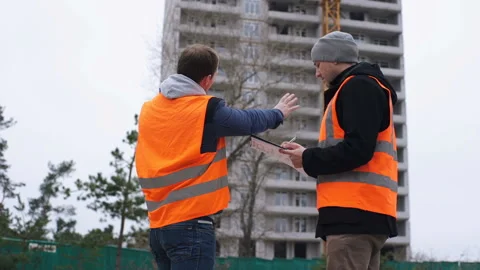 Two foreman at a construction site looking blueprints Stock Footage 89650669