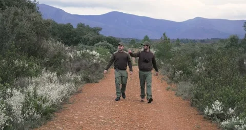 Two forest ranger men in uniform walking through nature. Forest guard Stock Footage 275853810