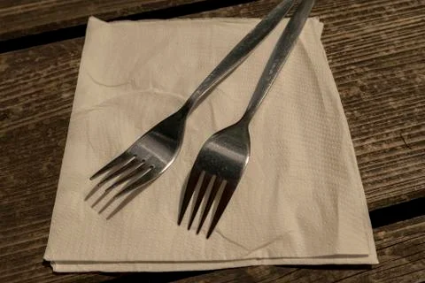 Two forks with napkin on the empty table Stock Photos