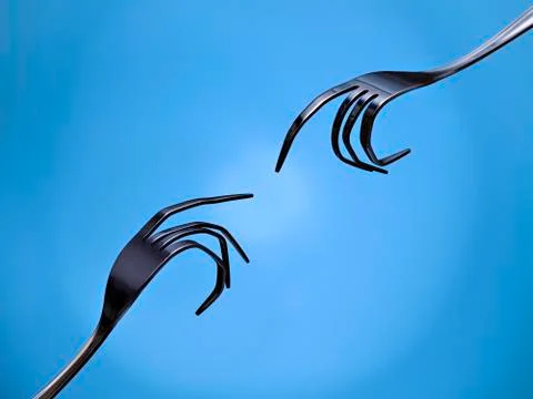 Two forks, pretending to be hands, trying to touch. Representation of Michelange Stock Photos