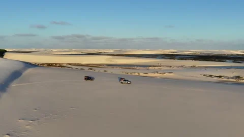 Two Four-Wheel-Drive Tour Vehicles Crossing Sand Between Shallow Lagoons Stock Footage 342444676