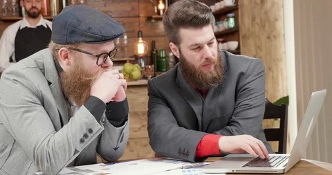 Two freelancers looking at the laptop screen and comparing the data Stock Footage 104971675
