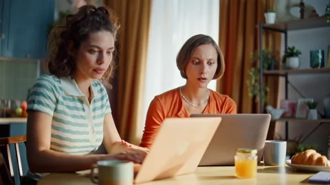 Two freelancers stressed failure browsing laptop at home kitchen closeup. Stock Footage 333792896