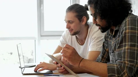 Two freelancers work at home at a computer with a laptop, sitting at a table Stock Footage 171536992