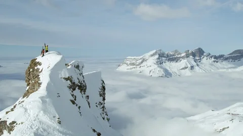 Two freeride skiers standing on summit in Swiss Alps looking at other peaks Stock Footage 129086253