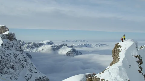 Two freeride skiers standing on summit in Swiss Alps overlooking other peaks Stock Footage 129086293