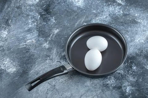 Two fresh chicken egg in frying pan Stock Photos