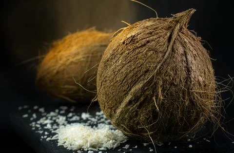 Two fresh coconuts and the coconut shavings Stock Photos