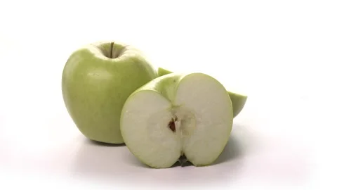Two fresh cutted green apples are spinning on white background. Freshly picked Stock Footage 148510778