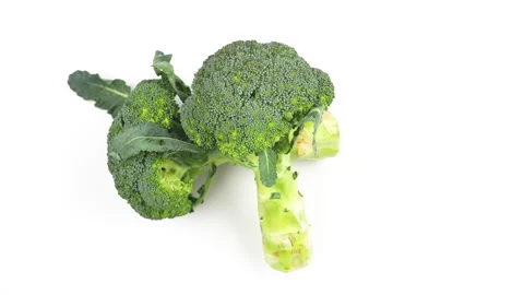 Two Fresh Green Broccoli Heads Rotating On White Background Top View Stock Footage 325968237