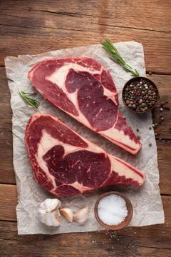 Two fresh raw marble meat, black Angus ribeye steak with spices on a old rust Stock Photos