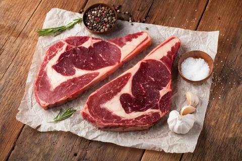 Two fresh raw marble meat, black Angus ribeye steak with spices on a old rust Stock Photos