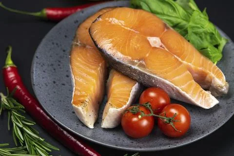 Two fresh raw salmon steaks with vegetables and spices: rosemary, tomatoes, bell Stock Photos