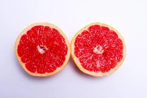 Two fresh red grapefruit halves on white background Stock Photos